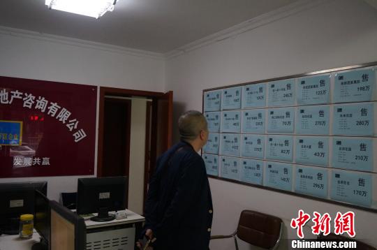 5月3日郑州楼市实行新的限购政策后,市民在房产中介看房子。 韩章云 摄